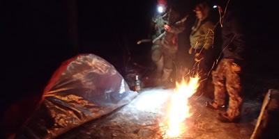 Fire Burning in front of a Survival Shelter